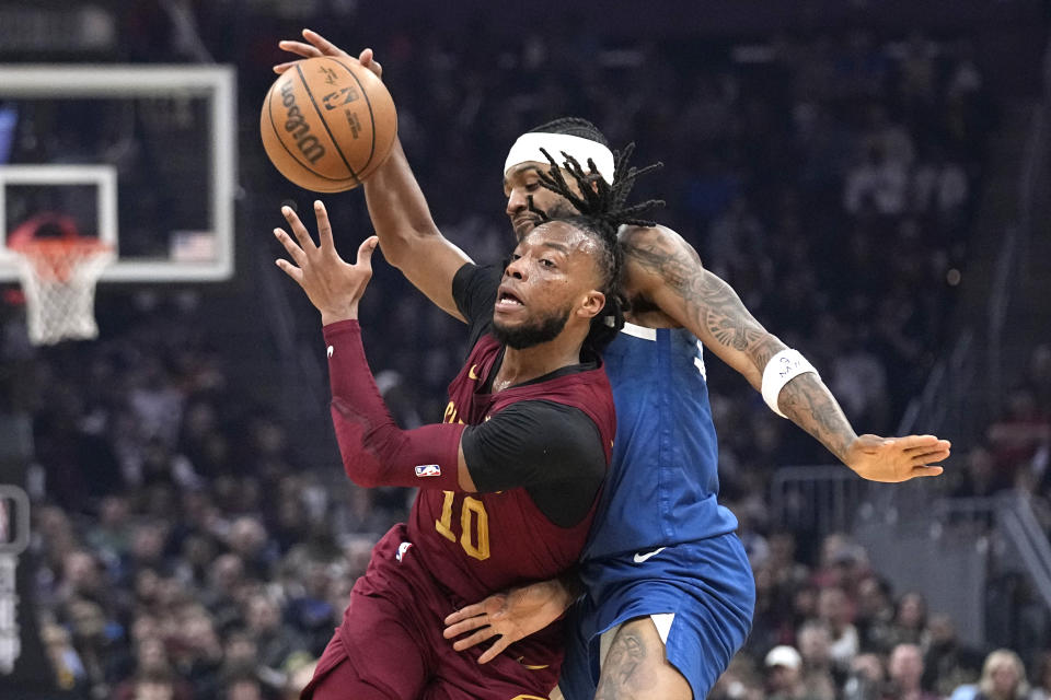 Cleveland Cavaliers guard Darius Garland (10) drives past Minnesota Timberwolves guard Nickeil Alexander-Walker during the first half of an NBA basketball game Friday, March 8, 2024, in Cleveland. (AP Photo/Sue Ogrocki)