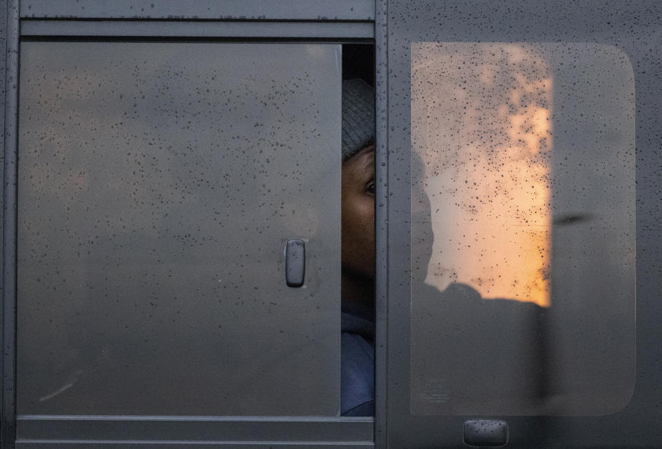 A passenger peeps through a window whilst sitting inside a minibus taxi during their journey to home in Kwa-Thema east of Johannesburg, South Africa, Tuesday, March 17, 2020. President Cyril Ramaphosa said all schools will be closed for 30 days from Wednesday and he banned all public gatherings of more than 100 people. South Africa will close 35 of its 53 land borders and will intensify screening at its international airports. For most people, the new COVID-19 coronavirus causes only mild or moderate symptoms. For some it can cause more severe illness. (AP Photo/Themba Hadebe)