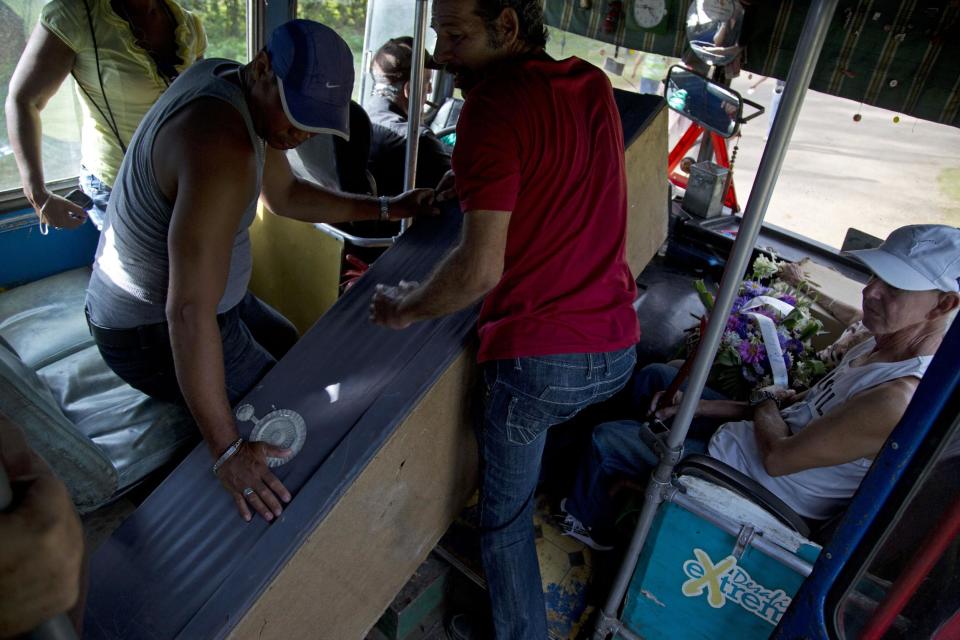In this Feb. 5, 2014 photo, people carry a mock coffin inside a bus as they head to the local cemetery to celebrate the Burial of Pachencho in Santiago de Las Vegas, Cuba. The celebration, about 12 miles south of the Cuban capital, has been held each Feb. 5 for the last 30 years, with an atmosphere that is more street-party than funeral. "Pachencho" is not representative of any real person, living or dead, explained Alvaro Hernandez, head of a learning and recreation center, "He's a product of popular imagination." (AP Photo/Enric Marti)