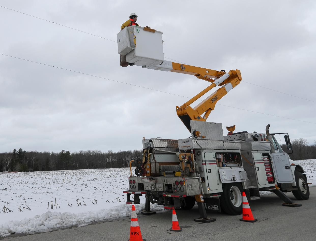 A Wisconsin Public Service worker repairs a power line on Thursday, April 4, 2024, along Chase Road near Pulaski, Wis. WPS is working to restore power to tens of thousands of customers in the wake of a winter storm system that hit northeastern Wisconsin earlier in the week.