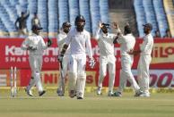 Cricket - India v England - First Test cricket match - Saurashtra Cricket Association Stadium, Rajkot, India - 10/11/16. England's Moeen Ali walks off the field as India's players celebrate his dismissal. REUTERS/Amit Dave