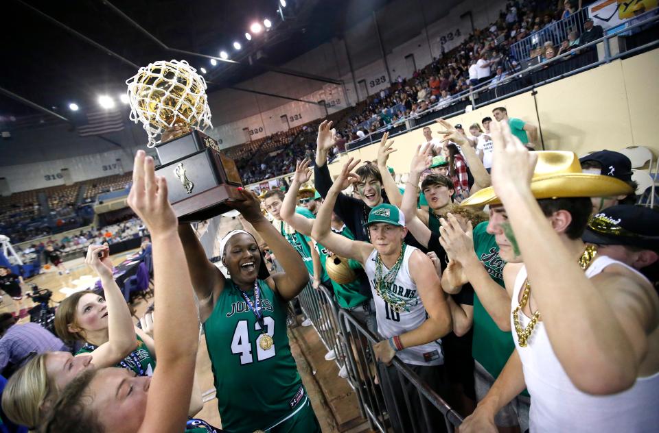 Jones' Sofi Woodson (42) holds the championship trophy as Jones celebrates the Class 3A girls state basketball championship with fans at the State Fair Arena in Oklahoma City, Saturday, March 11, 2023. 