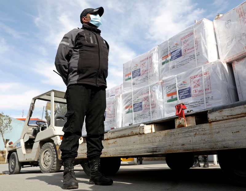 FILE PHOTO: An Indian security personnel stands guard neax to the boxes containing vials of COVISHIELD, a coronavirus disease (COVID-19) vaccine donated by Indian government in Kabul