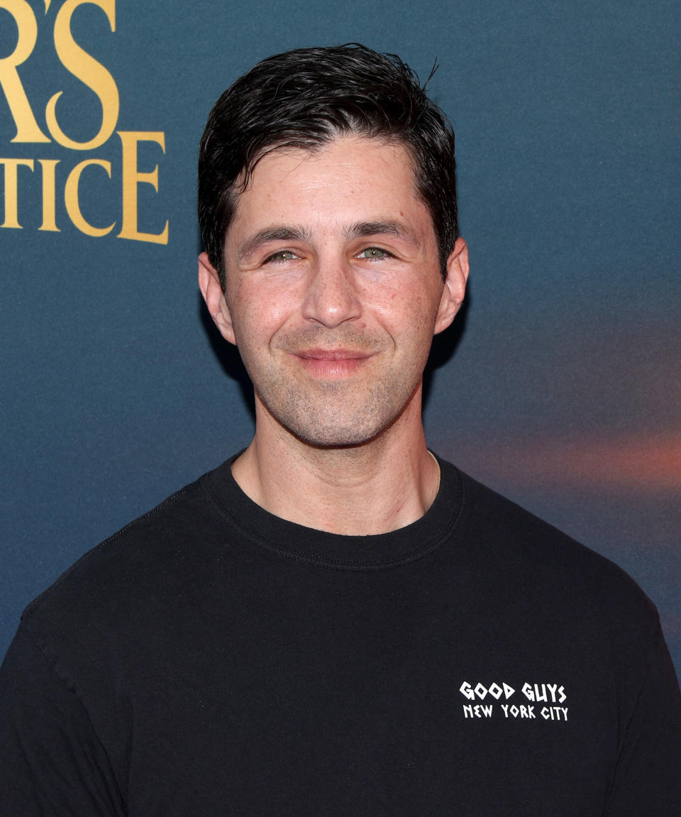 Josh smiling at event wearing a black "Good Guys New York City" T-shirt