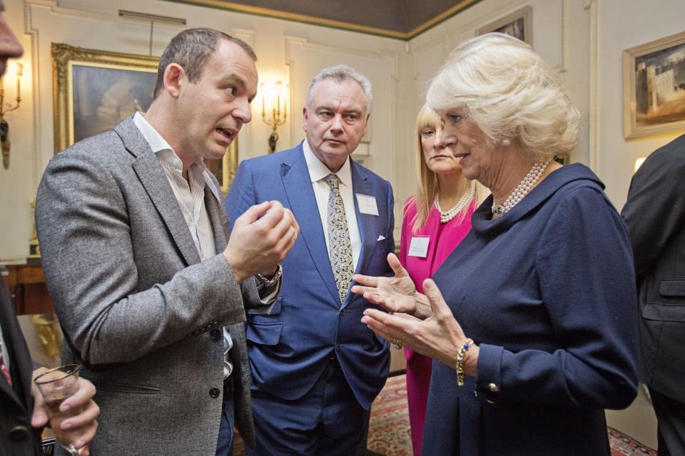 The Duchess of Cornwall speaks with money saving expert Martin Lewis (left) and Eamonn Holmes, as she hosts a reception to mark International Credit Union Day at Clarence House, London.