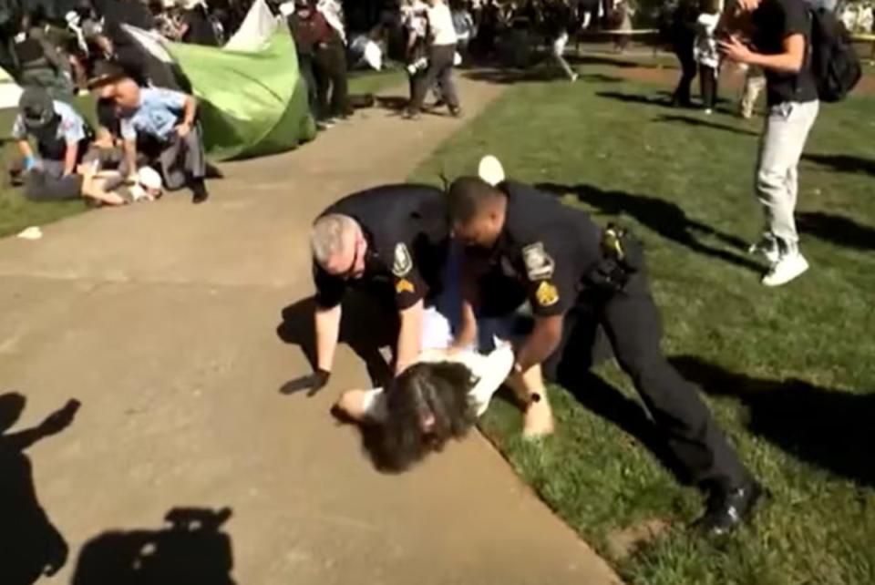 A woman, believed to be Caroline Fohlin, was restrained by police officers during  pro-Palestine protests at Emory University last Thursday (CNN)