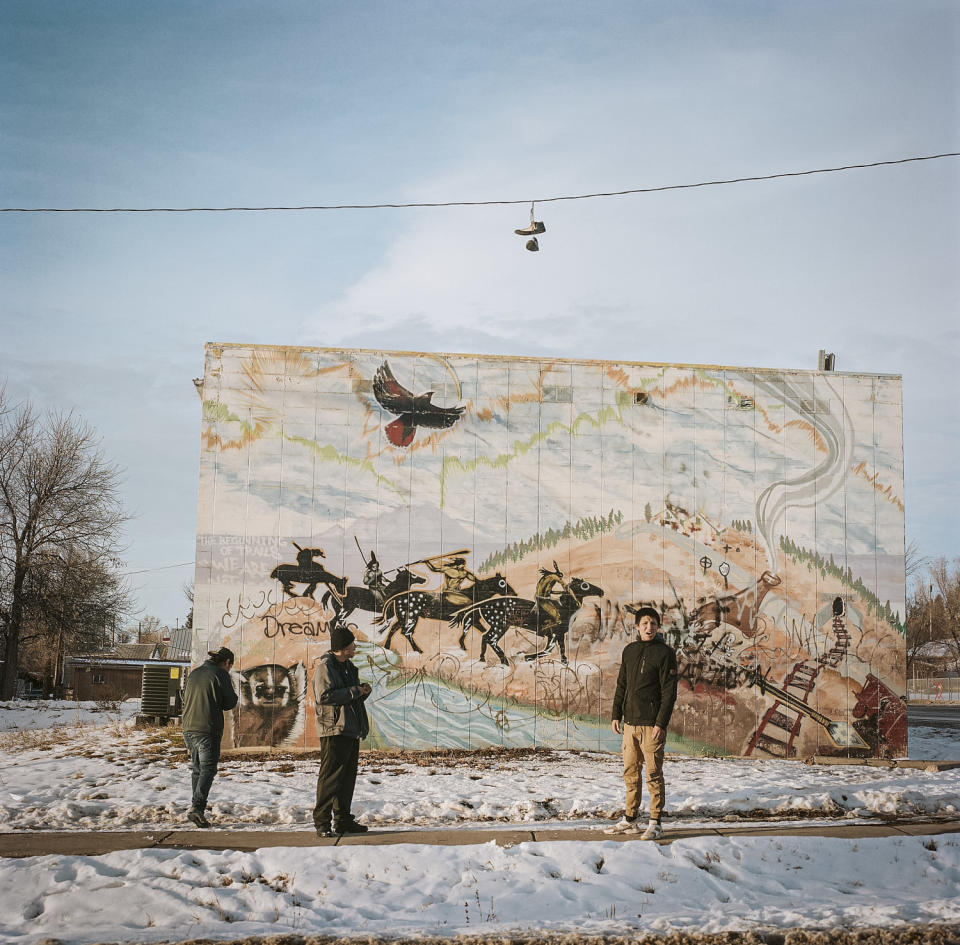 Men stand next to a mural in central Lame Deer on the Northern Cheyenne Reservation (Erin Trieb for NBC News)