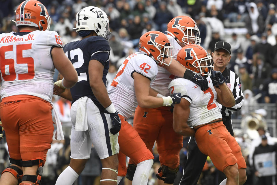 Illinois running back Chase Brown (2) celebrates with Michael Marchese (42) and Jack Badovinac after scoring on a second quarter touchdown run against Penn State during an NCAA college football game in State College, Pa., Saturday, Oct. 23, 2021. (AP Photo/Barry Reeger)