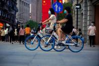 Woman ride bikes on a street, following the outbreak of the coronavirus disease (COVID-19), in Shanghai