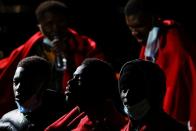 Migrants wait to disembark from a Spanish coast guard vessel, in the port of Arguineguin