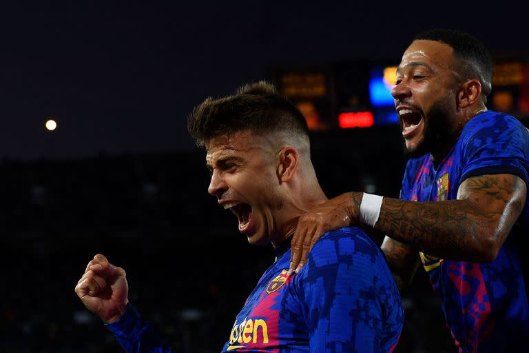 El neerlandés Memphis Depay se sube a los hombros de Gerard Piqué, autor del primer gol de Barcelona en el partido contra Dínamo de Kiev, por la fase de grupos de la Champions League.