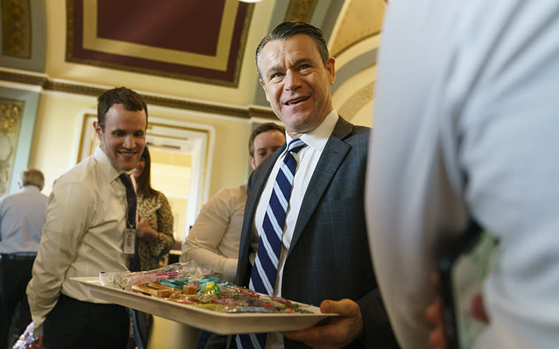 Sen. Todd Young (R-Ind.) passes out candy to members of the press