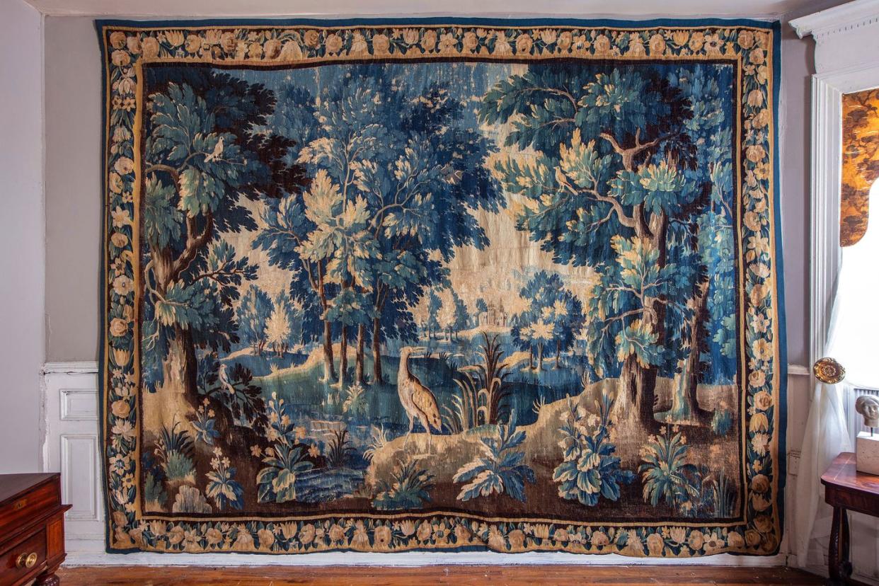 antique tapestry featuring a landscape