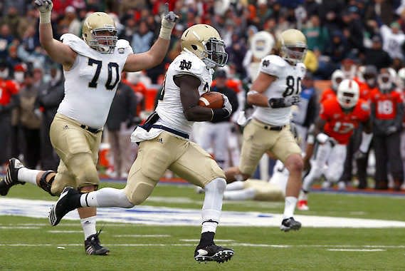 Notre Dame running back Cierre Wood (center) heads toward the end zone as teammate Dennis Mahoney (70) celebrates in the Sun Bowl against Miami (Fla.) in 2010.