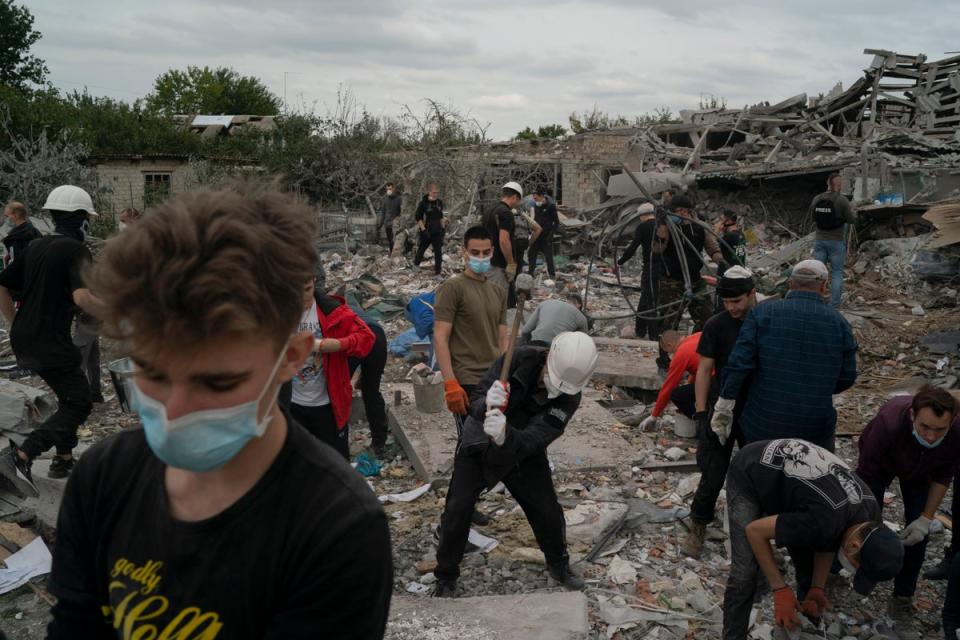 Volunteers work to clean the debris on a site where several houses were destroyed after a Russian attack at a residential area in Zaporizhzhia (AP)