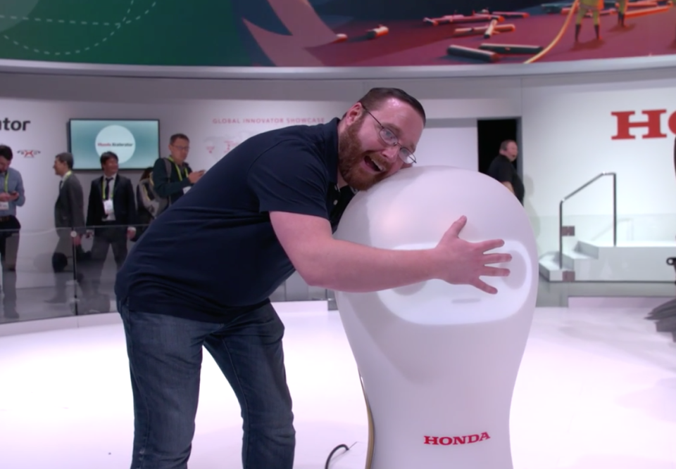 Yahoo Finance’s Dan Howley gives Honda’s 3E-A18 robot a hug.