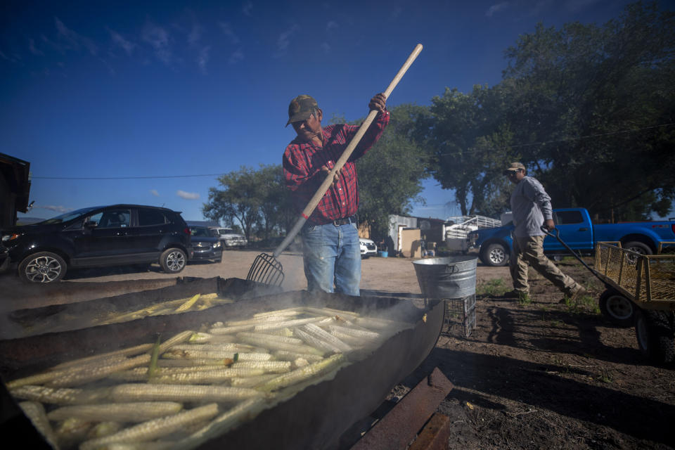 Farmer Eugene “Hutch” Naranjo boils corn at his home in Ohkay Owingeh, formerly named San Juan Pueblo, in northern New Mexico, Sunday, Aug. 21, 2022. Friends and relatives of the Naranjos gather every year to make chicos, dried kernels used in stews and puddings. (AP Photo/Andres Leighton)