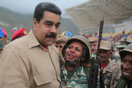 Venezuela's President Nicolas Maduro (L) poses for a photo with a militia member during a military parade in La Guaira, Venezuela May 21, 2016. Miraflores Palace/Handout via REUTERS