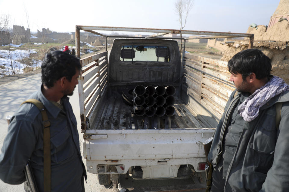 Afghan security personnel stand near a vehicle in which rockets were placed, in Bagram, north of Kabul, Afghanistan, Saturday, Dec. 19, 2020. Five rockets were fired at a major U.S. base in Afghanistan on Saturday, but there were no casualties, NATO and provincial officials said. (AP Photo/Rahmat Gul)