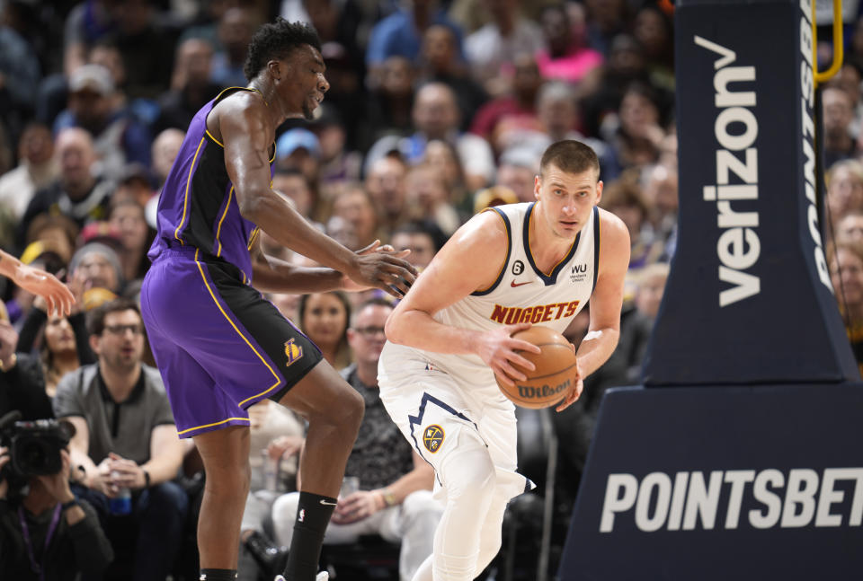 Denver Nuggets center Nikola Jokic, right, pulls in the ball as Los Angeles Lakers center Thomas Bryant defends in the first half of an NBA basketball game Monday, Jan. 9, 2023, in Denver. (AP Photo/David Zalubowski)