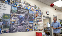 Joel Conner, Grand manager & Supervisor with Hendry County Adult Learning, looks at the success of past students on a wall of photos in the classroom of the Auto Mechanic Program on Thursday, March 14 ,2024. The center offers an alternative to adult education where students gain the necessary experience to receive certification and immediately enter the local workforce after completion in Clewiston, Fla. (AP Photo/Chris Tilley)