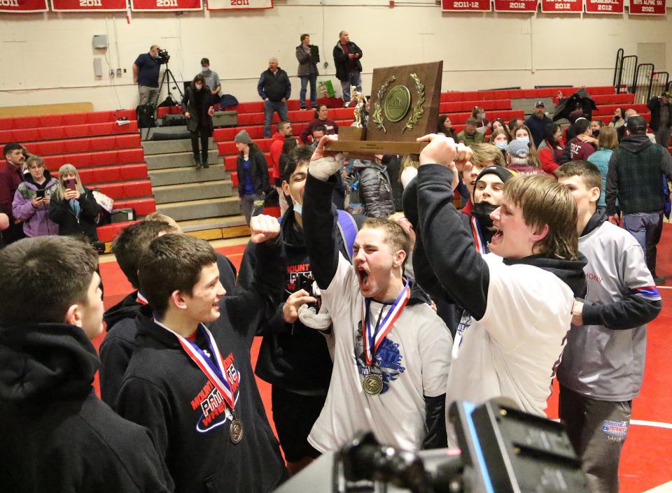 Mt. Anthony captains take possession of the trophy after securing its 33rd straight state title on Sunday night at CVU.
