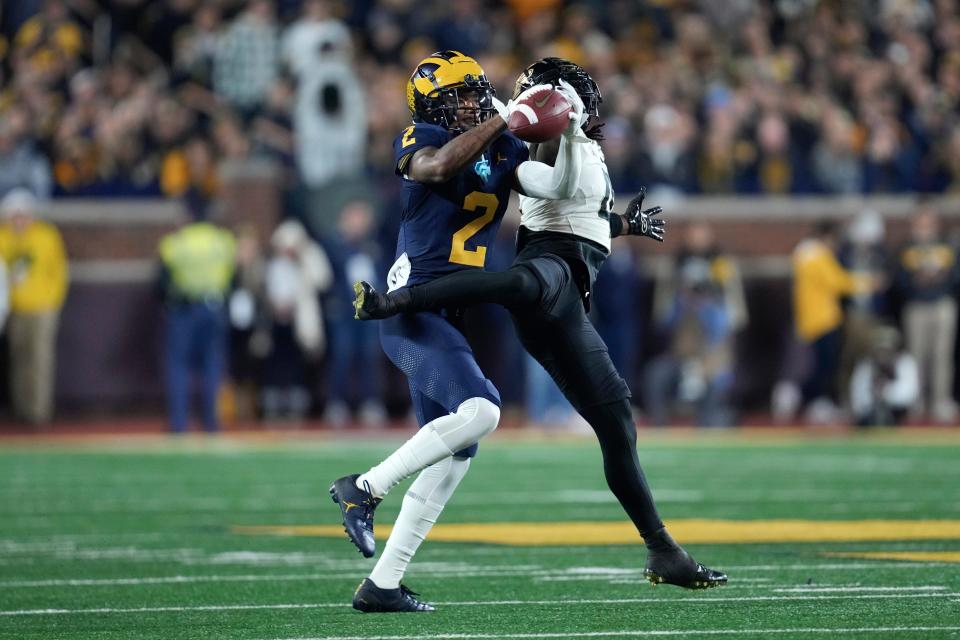Michigan defensive back Will Johnson (2) intercepts a pass intended for Purdue wide receiver Deion Burks (4) in the first half of an NCAA college football game in Ann Arbor, Mich., Saturday, Nov. 4, 2023. (AP Photo/Paul Sancya)