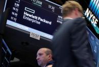 FILE PHOTO: A trader passes by the post where Hewlett Packard Enterprise Co., is traded on the floor of the New York Stock Exchange