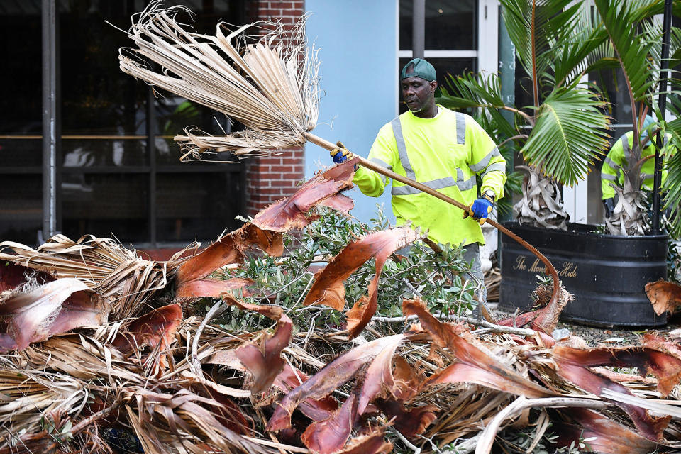 A worker cleans debris in downtown St. Petersburg after Hurricane Ian passed through the area on Sept. 29, 2022.