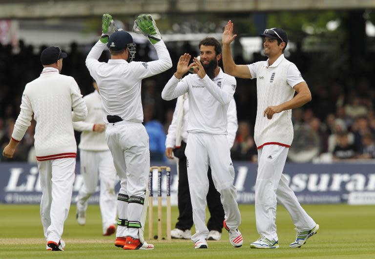 England's Moeen Ali (C) celebrates with Alastair Cook (R) and Jos Buttler after taking the wicket of New Zealand's Kane Williamson