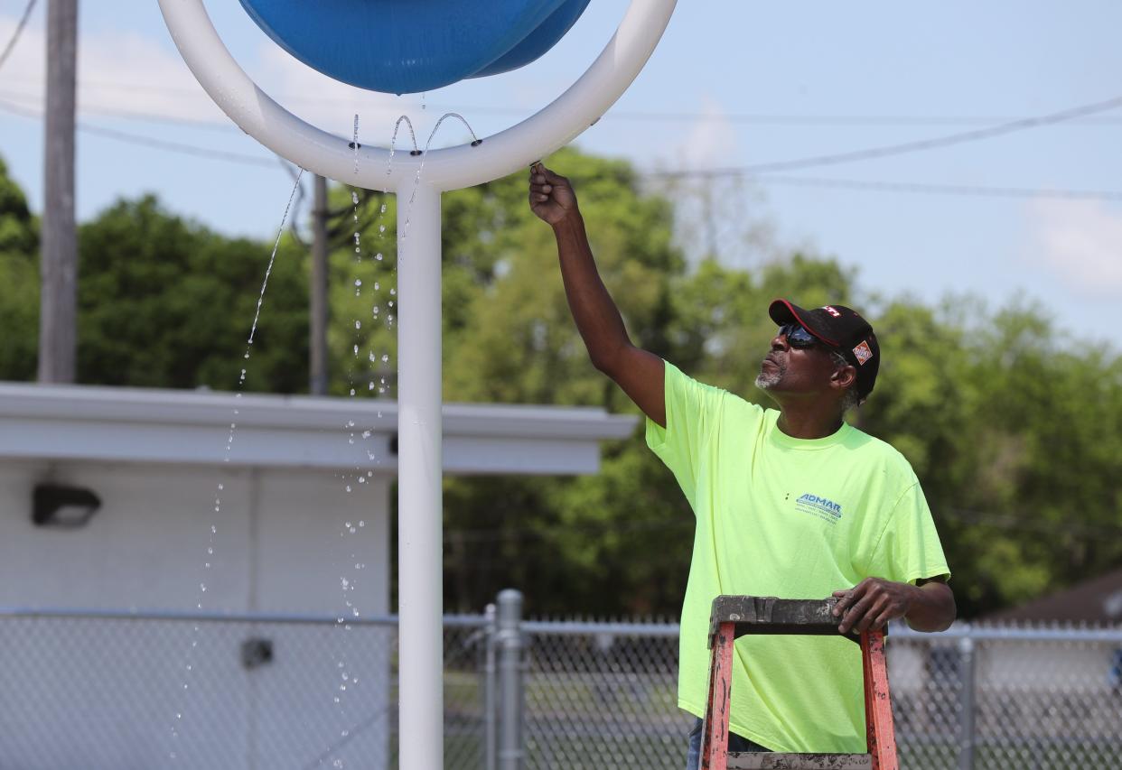 Danny McClain with Astro Pool Co. makes adjustments to one of the fixtures at the Gahanna Swimming Pool's new splash pad May 16.