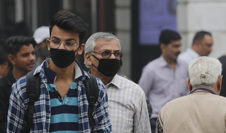 Indian walk wearing masks to protect against pollution in New Delhi, India, Thursday, Nov. 14, 2019. Schools in India's capital have been shut for Thursday and Friday after air quality plunged to a severe category for the third consecutive day, enveloping New Delhi in a thick gray haze of noxious air. (AP Photo/Manish Swarup)