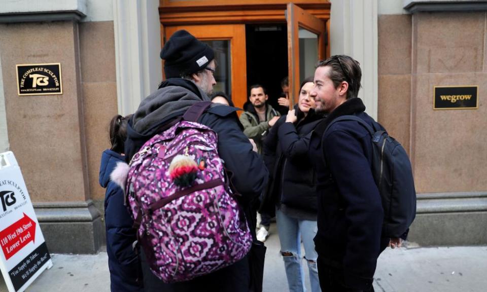 Laid-off WeWork employees gather on sidewalk outside WeWork corporate headquarters in Manhattan, New York.