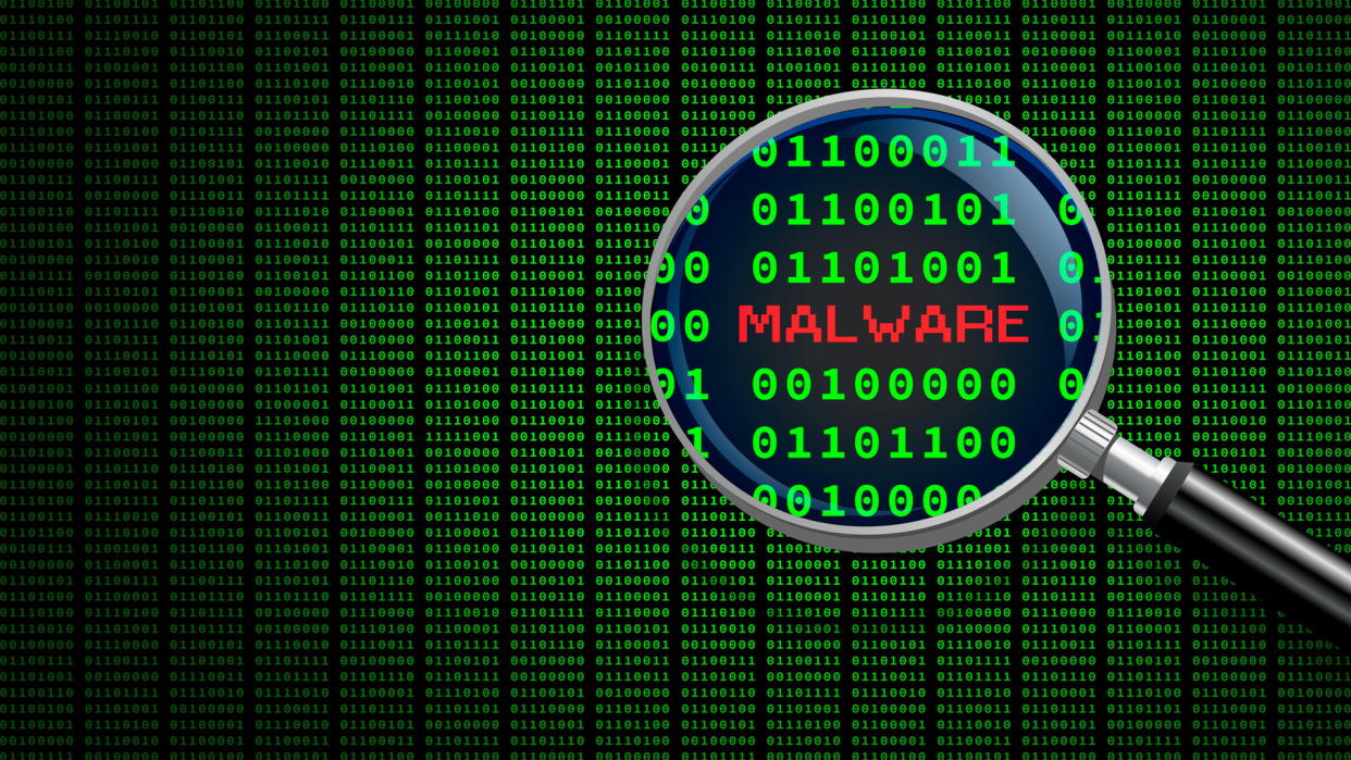  Magnifying glass enlarging the word 'malware' in computer machine code. 