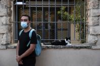 Actor and theater director Aris Laskos poses outside the Theater of Neos Kosmos in Athens, Thursday, Oct. 1, 2020. Laskos based in Athens, hasn't worked since early February and received a one-off support check for 800 euros ($940) shortly after the country's economy was placed in lockdown in the spring due to the pandemic. (AP Photo/Thanassis Stavrakis)