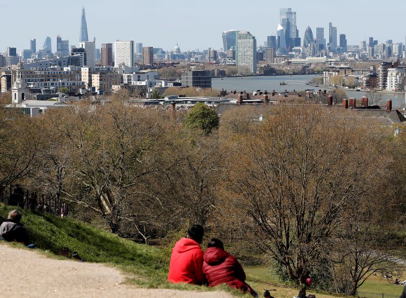 FILE PHOTO: Visitors to Greenwich Park sit and look towards the City of London as lockdown restrictions are eased amidst the spread of the coronavirus disease (COVID-19) pandemic in London