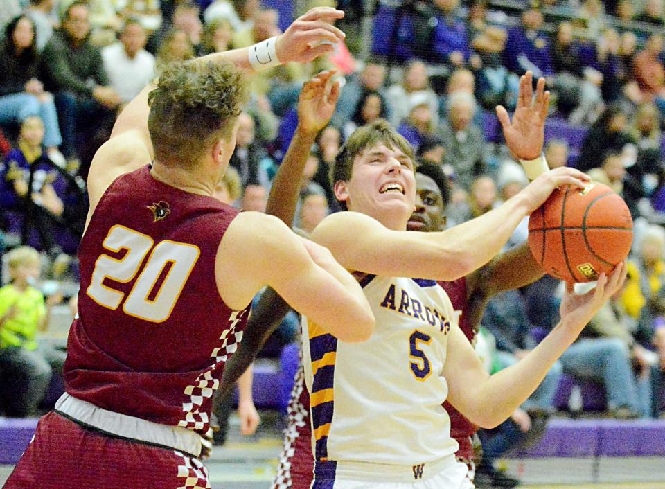 Watertown's Caden Beauchamp is trapped by yeo Sioux Falls Roosevelt defenders including Jackson Brouwer (20) during their high school boys basketball game on Friday, February 10, 2023 in the Watertown Civic Arena.