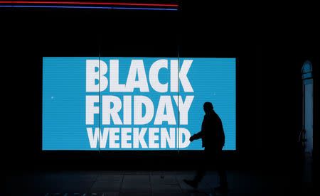 A man is silhouetted against an illuminated sign on 'Black Friday' in the West End shopping district of London, Britain November 24, 2017. REUTERS/Simon Dawson