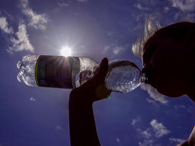 Trinken, trinken, trinken: Eine junge Frau setzt die Wasserflasche an. Foto: Paul Zinken