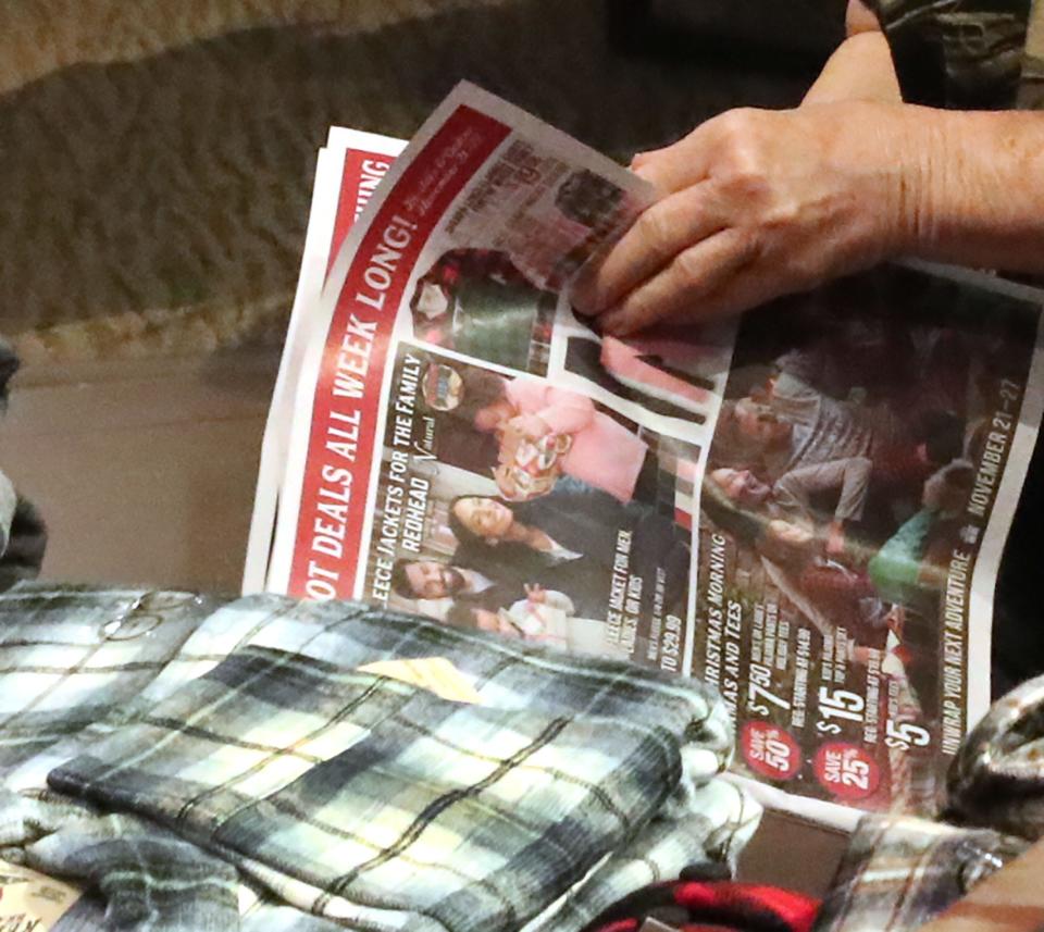 A shopper browses sale pamphlet on Monday at the Bass Pro Shops at One Daytona in Daytona Beach. Although many shoppers started their holiday buying early this year, retailers still expect big crowds for Black Friday, the traditional start of the holiday shopping season.