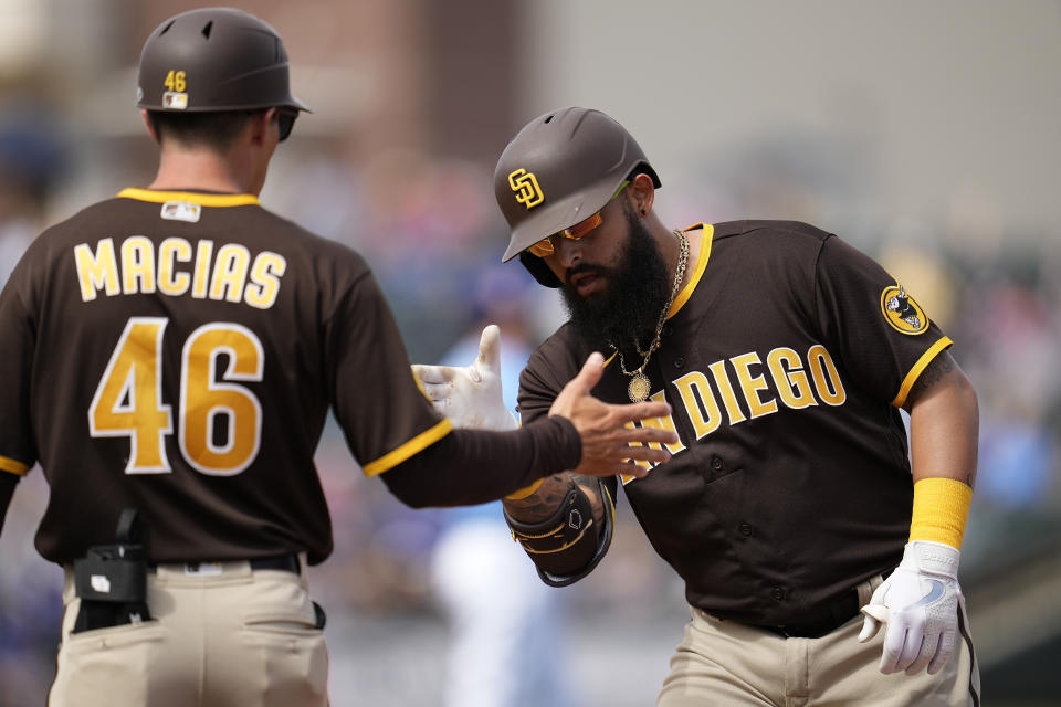 San Diego Padres' Rougned Odor celebrates with first base coach David Macias after hitting a single during the second inning of a spring training baseball game against the Kansas City Royals, Friday, March 10, 2023, in Surprise, Ariz. (AP Photo/Abbie Parr)