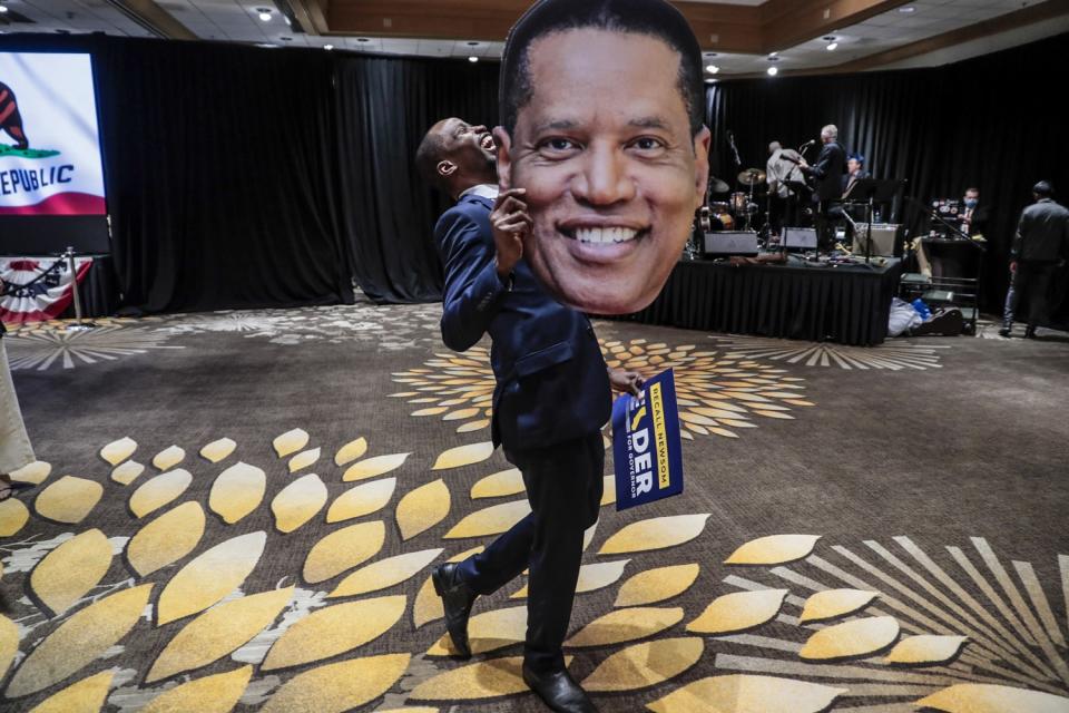 Errol Webber of Costa Mesa holds a cutout of a face