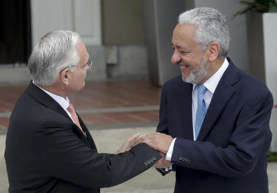 Outgoing Panama Canal Administrator Jorge Quijano, left, shakes hands with Ricaurte Vasquez, the Panama Canal's new administrator, during a swearing-in ceremony at the Panama Canal Administration Building in Panama City, Thursday, Sept. 5, 2019. Vasquez will administer the canal for a seven-year period and replaces Jorge Quijano. (AP Photo/Arnulfo Franco)