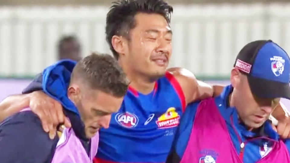 Lin Jong, pictured here in tears as he was helped from the field.