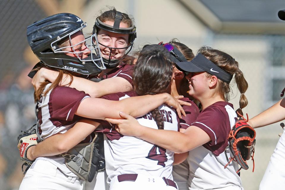 Prout softball players celebrate at East Greenwich High School after the Crusaders' victory in a playoff game last June.