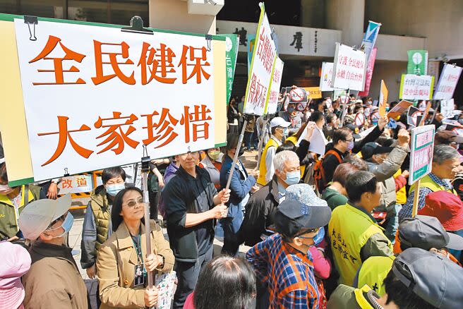 台派聯盟12日舉行「反對洗人口修法—中國配偶入籍條件應比照其他國家人士辦理」記者會，與會民眾高舉「全民健保 大家珍惜」標語。（杜宜諳攝）