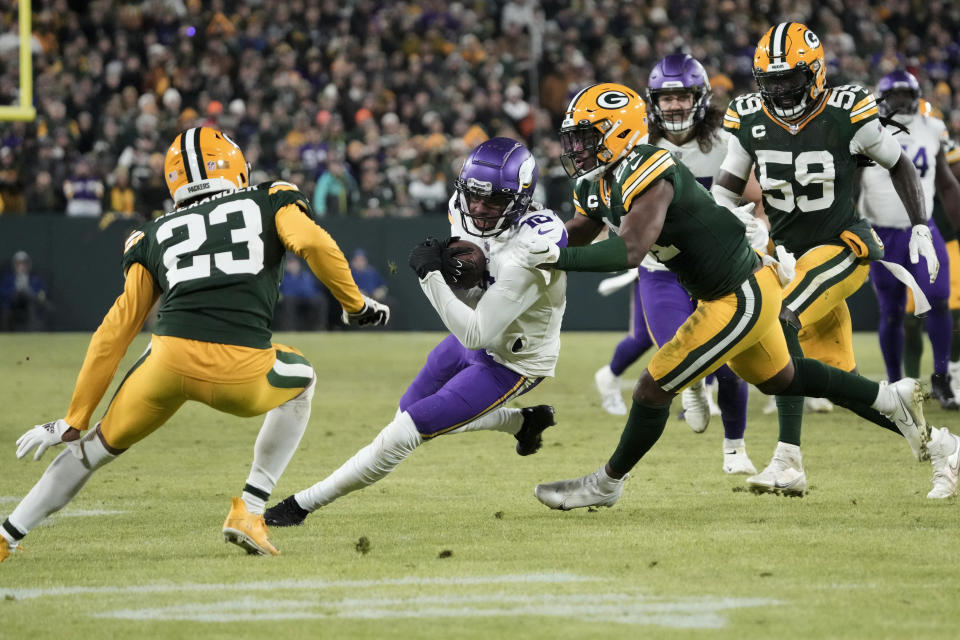 Minnesota Vikings wide receiver Justin Jefferson (18) catches a pass between Green Bay Packers cornerback Jaire Alexander (23) and safety Adrian Amos (31) during the second half of an NFL football game, Sunday, Jan. 1, 2023, in Green Bay, Wis. (AP Photo/Morry Gash)