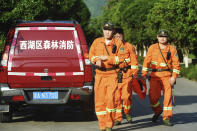 Workers take part in a search for a runaway leopard in Hangzhou in eastern China's Zhejiang province Sunday, May 9, 2021. A search for the last of three leopards that escaped from a safari park in eastern China was ongoing, authorities said Monday, May 10, 2021 as the park came under fire for concealing the breakout for nearly a week. (Chinatopix via AP)