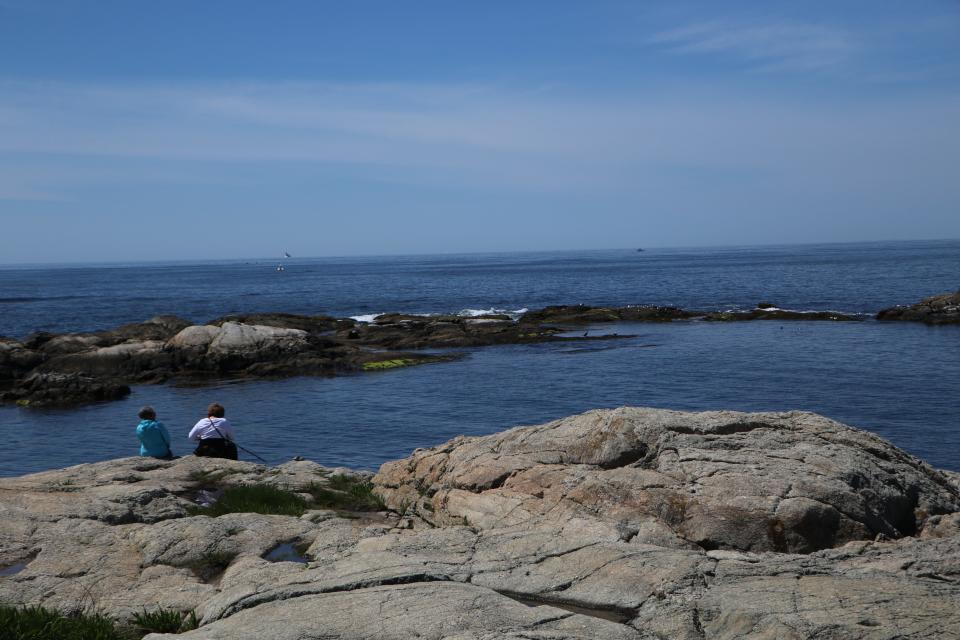 Nadia Nashid, who has an apartment in Newport, and Sawsan Hanna, of Virginia, sit on the rocks along the southernmost stretch of the Cliff Walk.