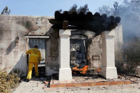 A firefighter checks a home that was burned in the so-called Sand Fire in the Angeles National Forest near Los Angeles, California, U.S. July 24, 2016. REUTERS/Jonathan Alcorn